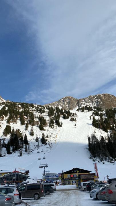 Een uitzicht op de Oostenrijkse bergen. De skiliften brengen skiërs naar boven, de lucht is blauw.