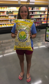Kim poseert in een supermarkt met een zak popcorn die even groot is als haar bovenlichaam.